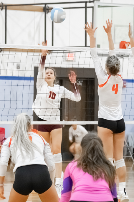 Women's volleyball player attacking at the net
